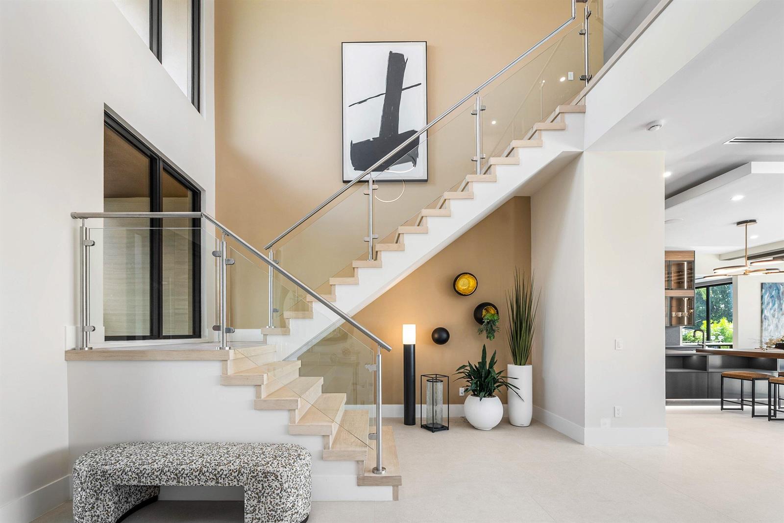 A modern staircase with glass railings and light wood treads sits against a tan wall — 728 Enfield Street, Boca Raton FL 33487, BOCA RATON, FL
