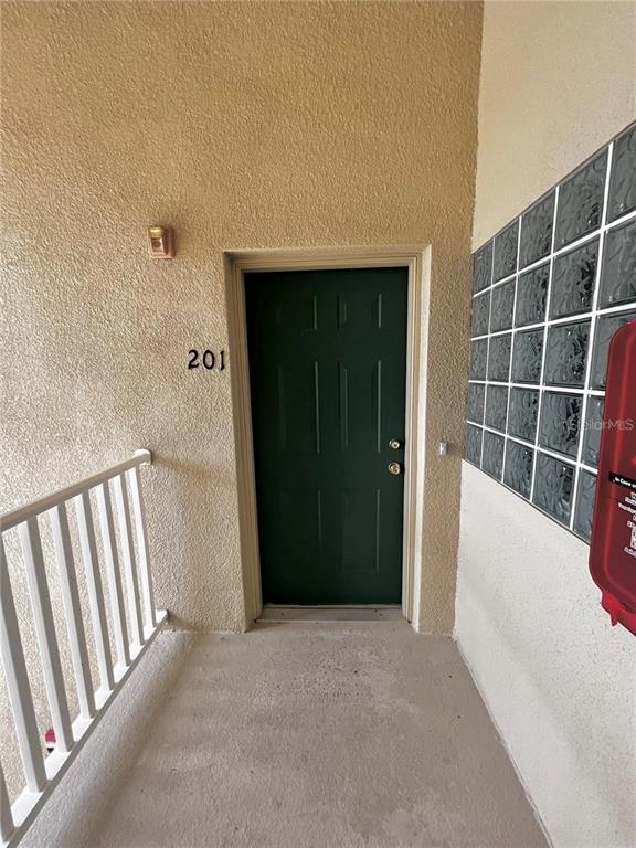 A green door labeled 201 is located on a balcony with a white railing — 6011 SKYDALE WAY UNIT 201, RIVERVIEW, FL