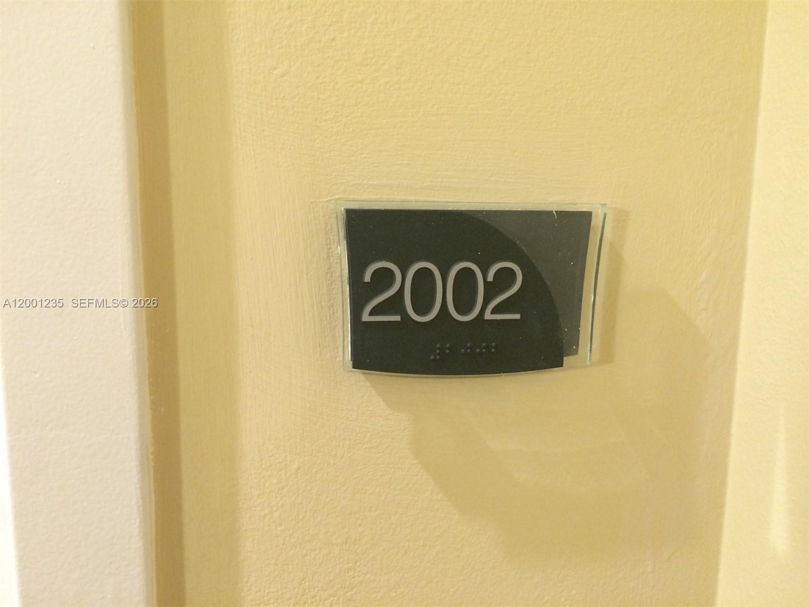 A close-up view of a room number sign labeled 2002 mounted on a wall — 1755 E Hallandale Beach Blvd # 2002E, Hallandale Beach FL 33009, HALLANDALE BEACH, FL