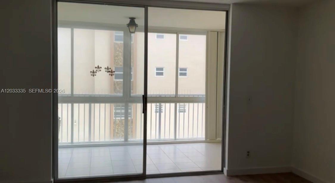 A room with a sliding glass door leading to a tiled balcony with railings — 201 SE 11th Ter # 302, Dania Beach FL 33004, DANIA BEACH, FL