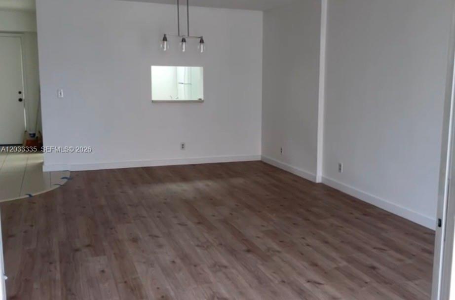 An empty room with light wood-look flooring, white walls, and a pass-through window — 201 SE 11th Ter # 302, Dania Beach FL 33004, DANIA BEACH, FL