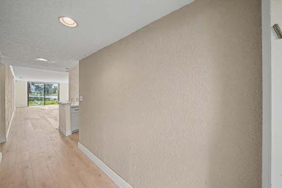 An exterior view of a multi-story apartment building with a covered walkway and parking lot — 15075 Witney Road # 108, Delray Beach FL 33484, DELRAY BEACH, FL