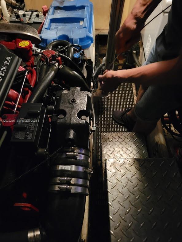 A person works on a marine engine inside a boat's engine compartment — 1700 NW 97 AVE, SUITE 227641, Miami FL 33172, MIAMI, FL