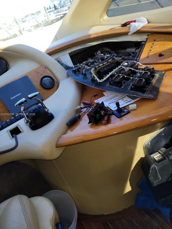 A boat cockpit console is undergoing electrical repairs with exposed wiring and removed control panels — 1700 NW 97 AVE, SUITE 227641, Miami FL 33172, MIAMI, FL