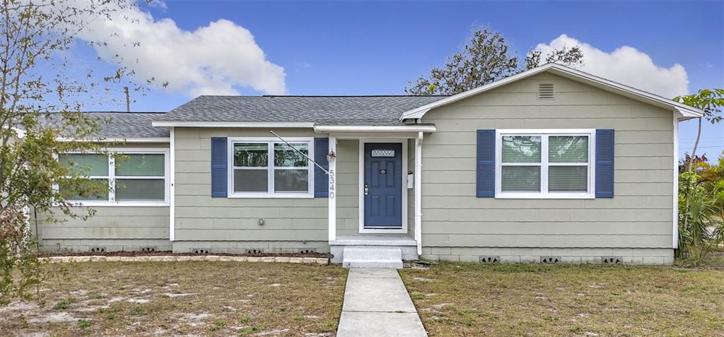 A single-story house with light green siding, blue shutters, and a blue front door — 5340 5TH AVENUE S, ST PETERSBURG, FL
