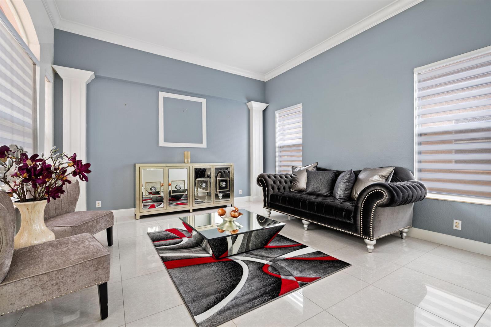 A living room features a black tufted sofa, mirrored furniture, and a patterned area rug — 658 Cresta Circle, West Palm Beach FL 33413, WEST PALM BEACH, FL
