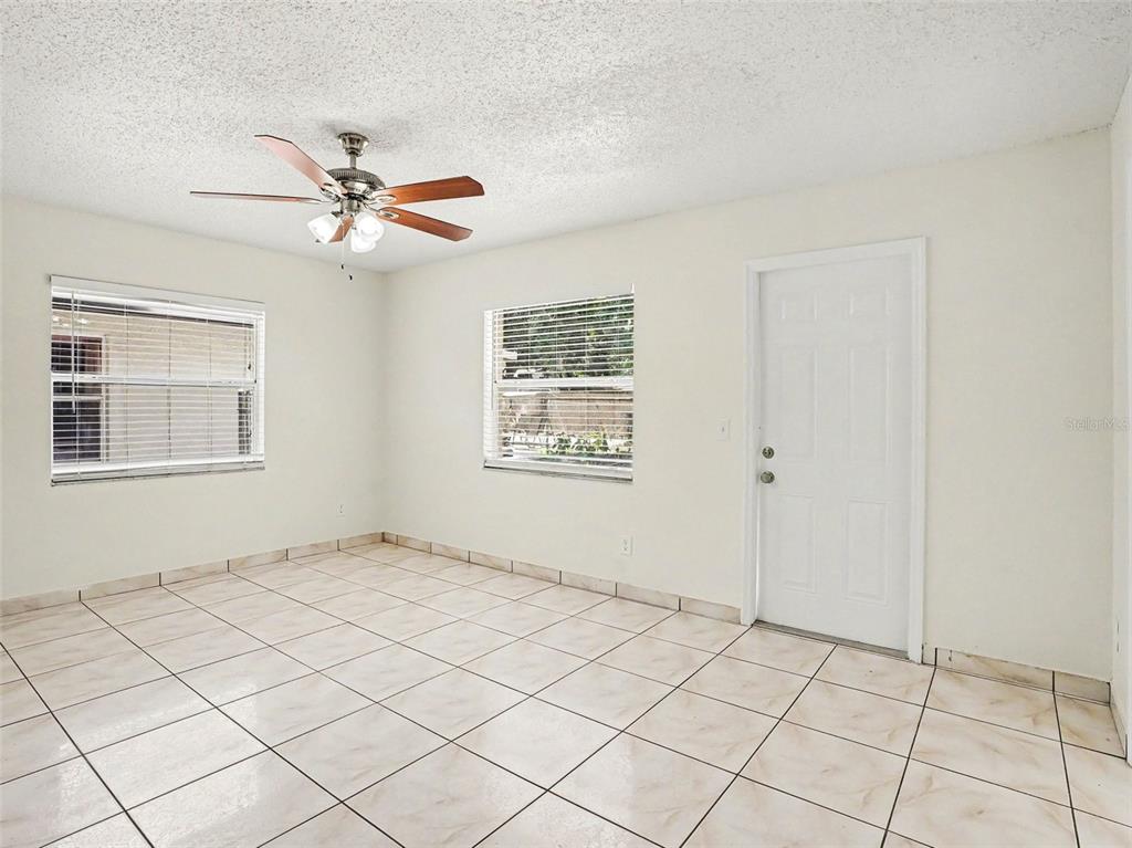 A room with white walls, tiled floors, a ceiling fan, and two windows — 9910 N DEAN OAKS COURT, ORLANDO, FL