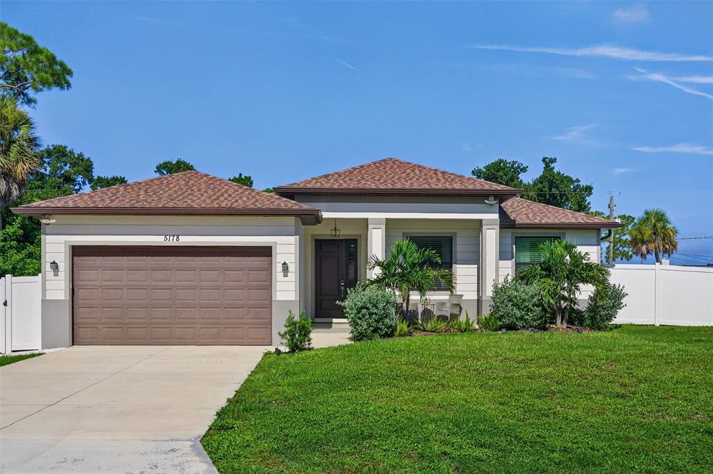 A single-story house with a brown roof, tan siding, and a two-car garage — 5178 FLORIDA ROAD, VENICE, FL