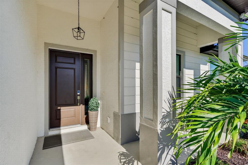 A covered front porch features a dark brown door, a hanging lantern, and a decorative pillar — 5178 FLORIDA ROAD, VENICE, FL