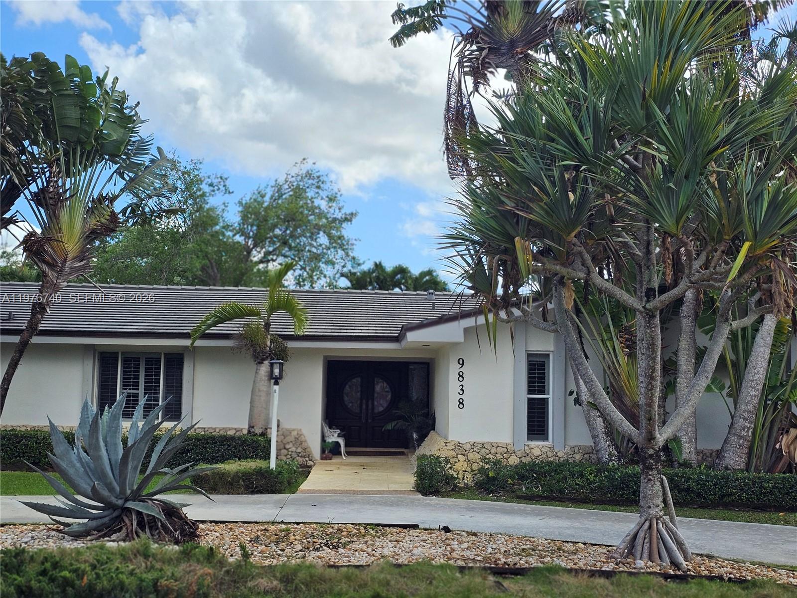 A single-story house with a white facade, stone accents, and a circular front door — 9838 SW 94th Ter, Miami FL 33176, MIAMI, FL