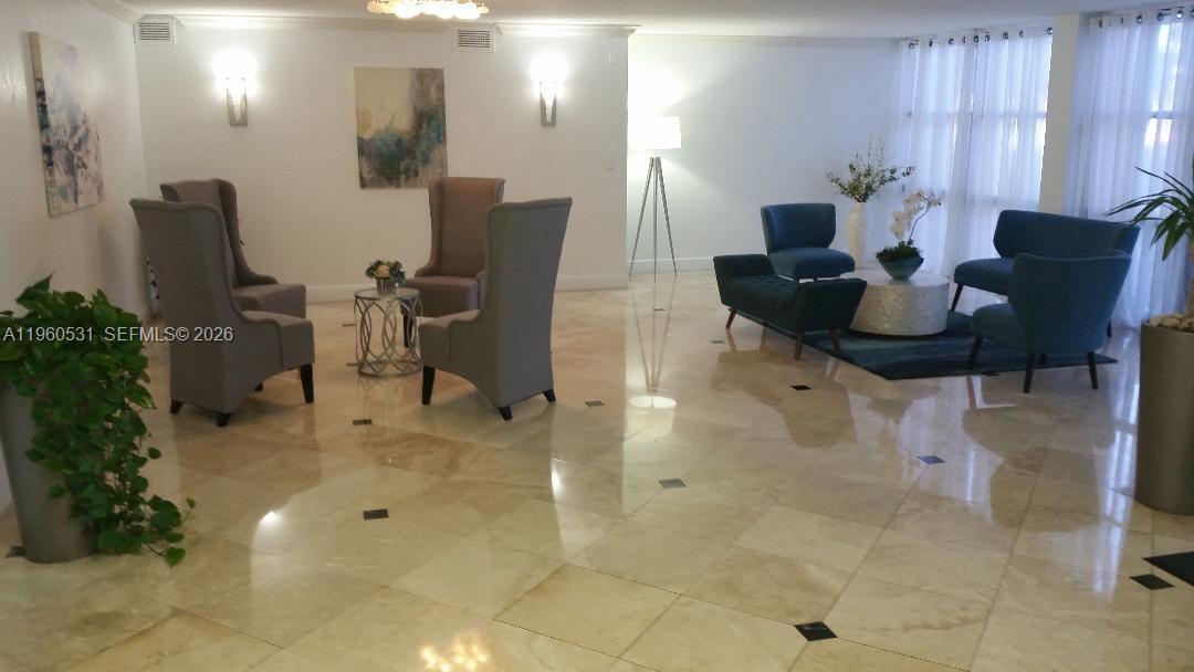 A spacious lobby features polished tile floors, two distinct seating areas, and wall sconces — 800 Parkview Dr # 416, Hallandale Beach FL 33009, HALLANDALE BEACH, FL