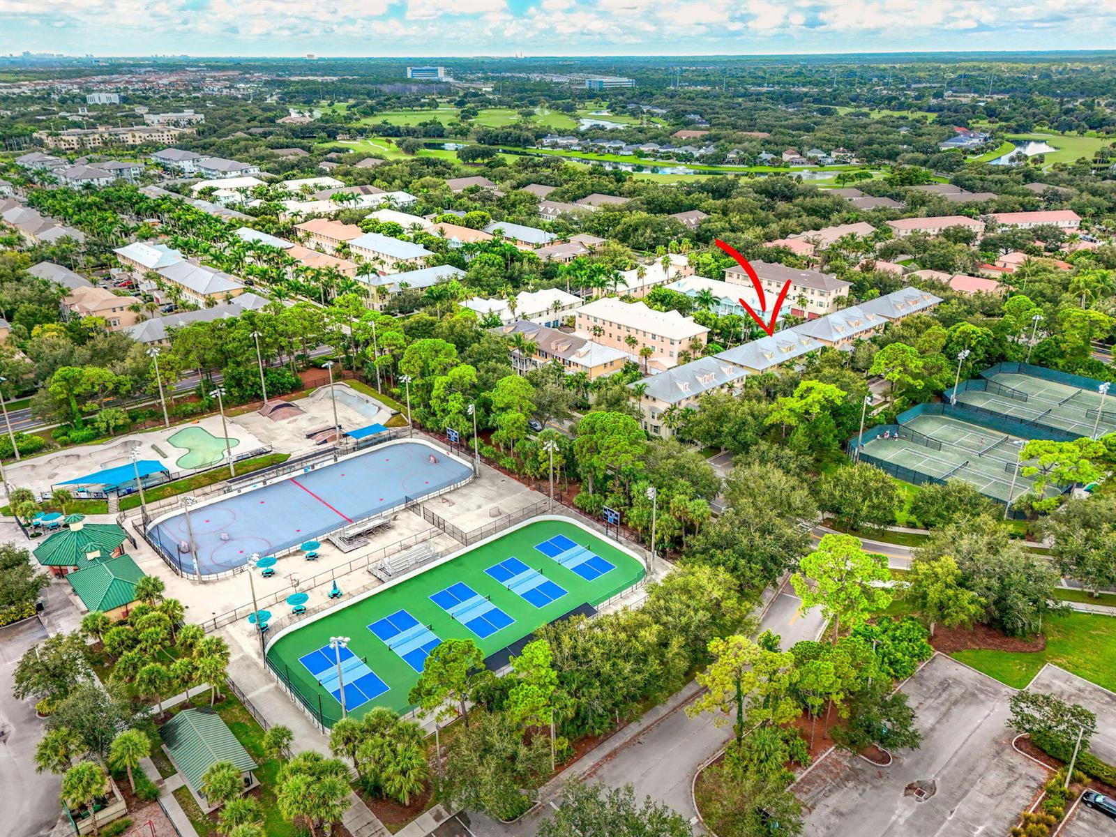 An aerial view shows a residential building complex next to a park with sports courts — 1562 Grande Cull Way, Jupiter FL 33458, JUPITER, FL