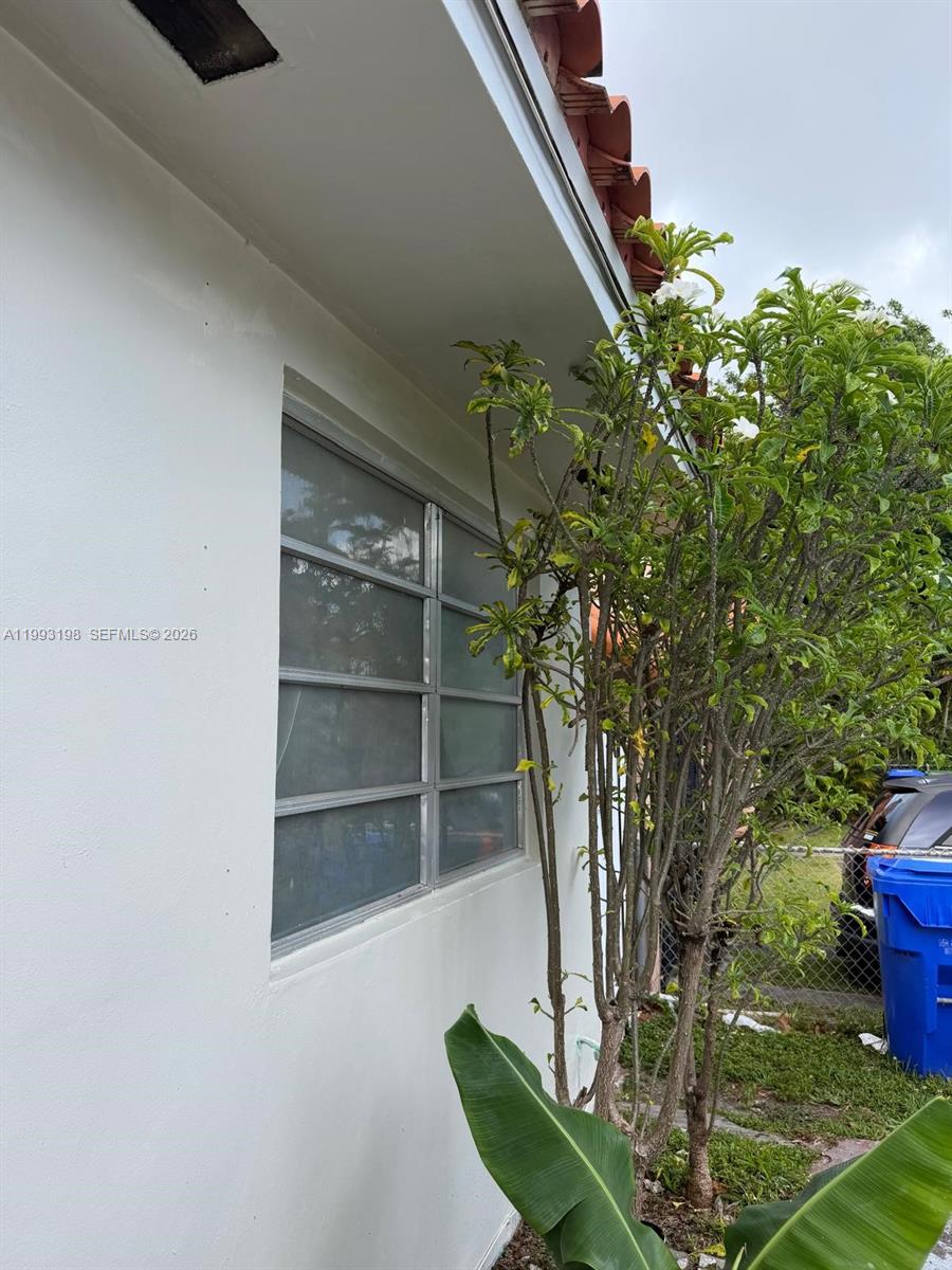 An exterior view shows a white wall with a window and a nearby flowering shrub — 2353 SW 2nd St, Miami FL 33135, MIAMI, FL