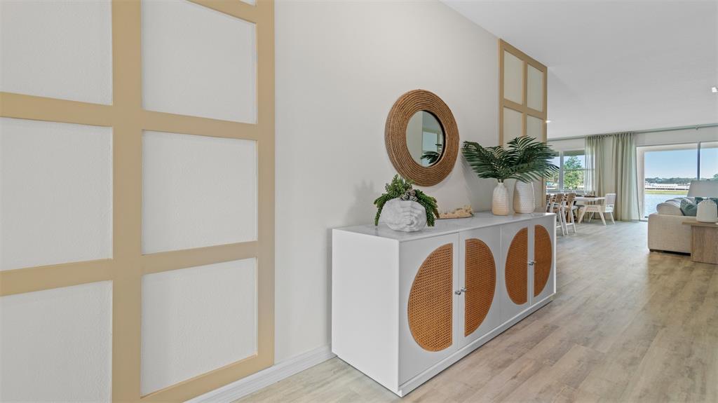 A white sideboard with rattan doors sits against a wall with decorative wood trim — 3032 KINGSMAN TRAIL, ORMOND BEACH, FL