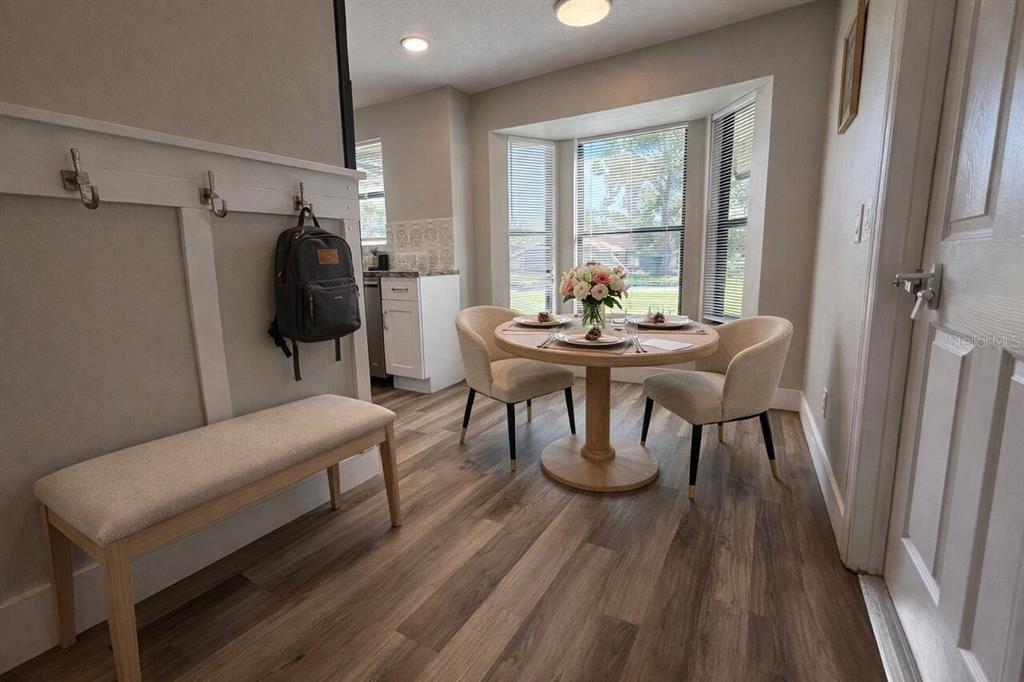 A dining area features a round table, two chairs, a bench, and a bay window — 1413 SANDALWOOD DRIVE, PLANT CITY, FL