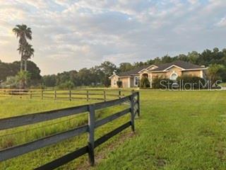 An aerial view shows a house and a detached building on a large fenced lot — 1500 NW 114TH LOOP, OCALA, FL