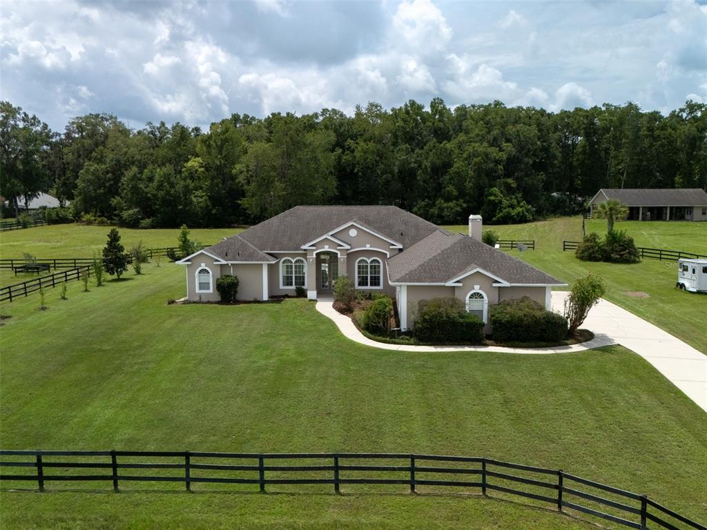 An aerial view of a single-story house with a tan exterior and a dark roof — 1500 NW 114TH LOOP, OCALA, FL