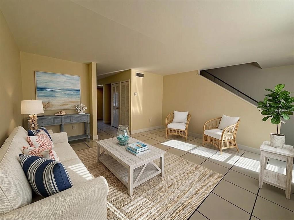 A living room features a beige sofa, two rattan chairs, and a light wood coffee table — 4033 HENLEY ROAD UNIT 1707, ORLANDO, FL