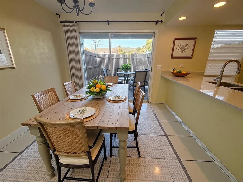 A dining area with a wooden table, chairs, and a sliding door leading to a patio — 4033 HENLEY ROAD UNIT 1707, ORLANDO, FL