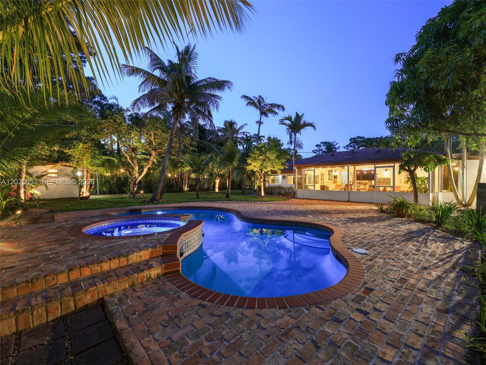 A backyard features a brick patio, a kidney-shaped swimming pool, a hot tub, and palm trees — 5644 SW 69th Ave, Miami FL 33143, MIAMI, FL