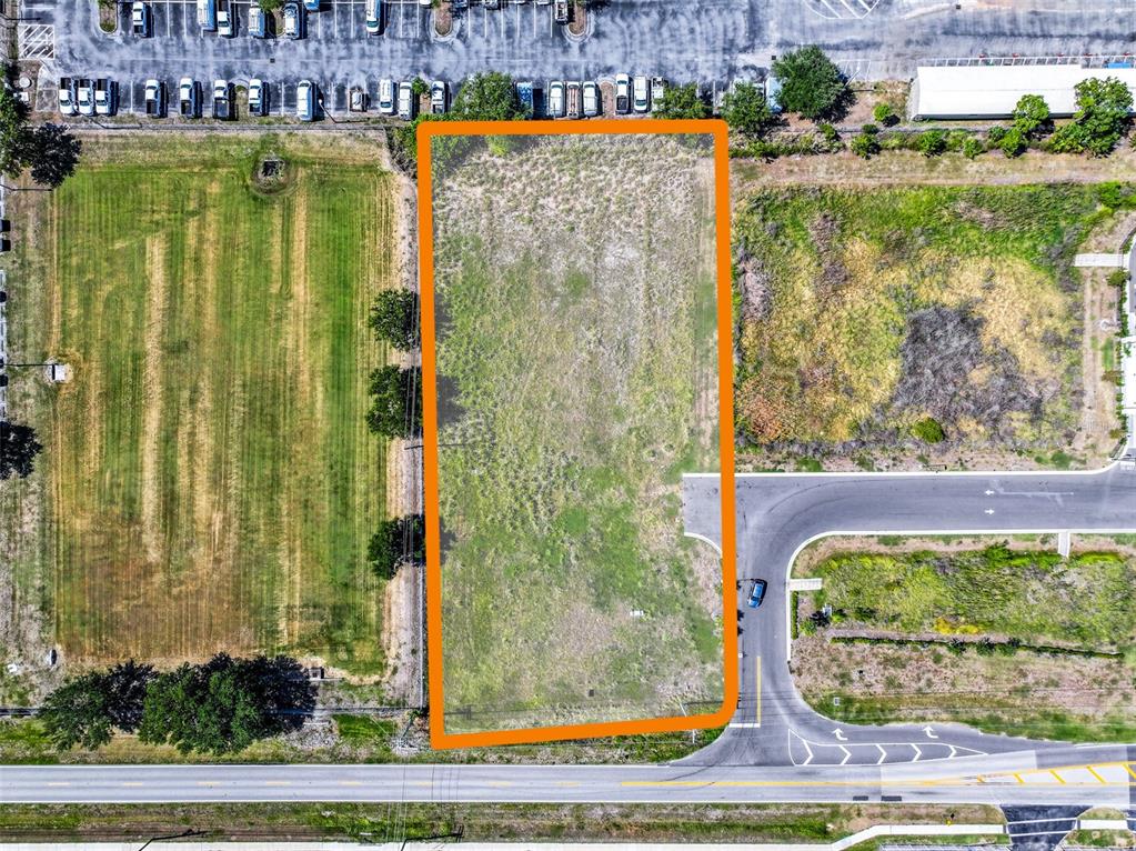 An aerial view shows a rectangular vacant lot outlined in orange next to paved roads — 2814 26TH AVENUE E, BRADENTON, FL