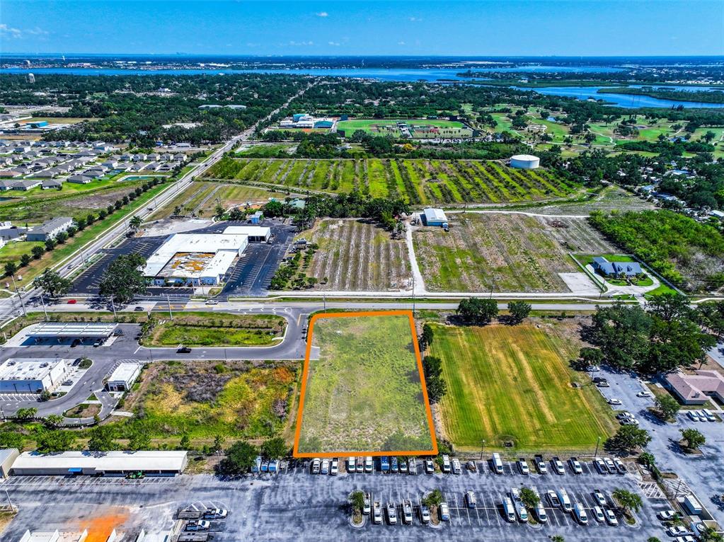 An aerial view shows a vacant, rectangular plot of land outlined in orange near a road — 2814 26TH AVENUE E, BRADENTON, FL