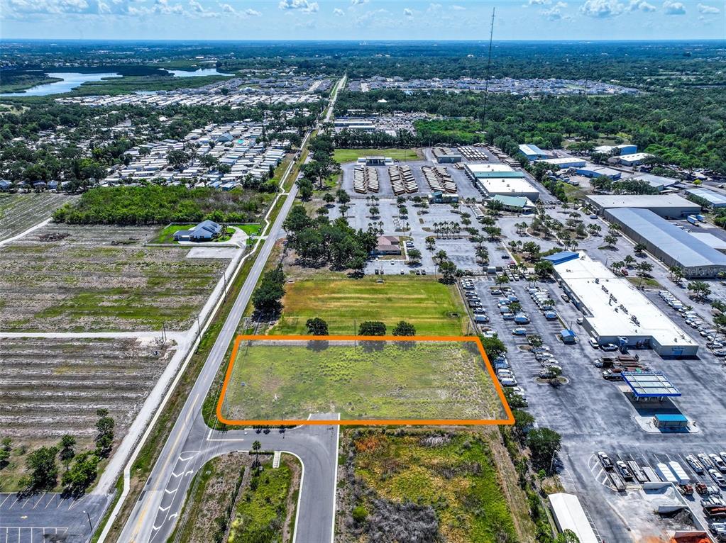 An aerial view shows a vacant rectangular lot outlined in orange near a commercial area — 2814 26TH AVENUE E, BRADENTON, FL
