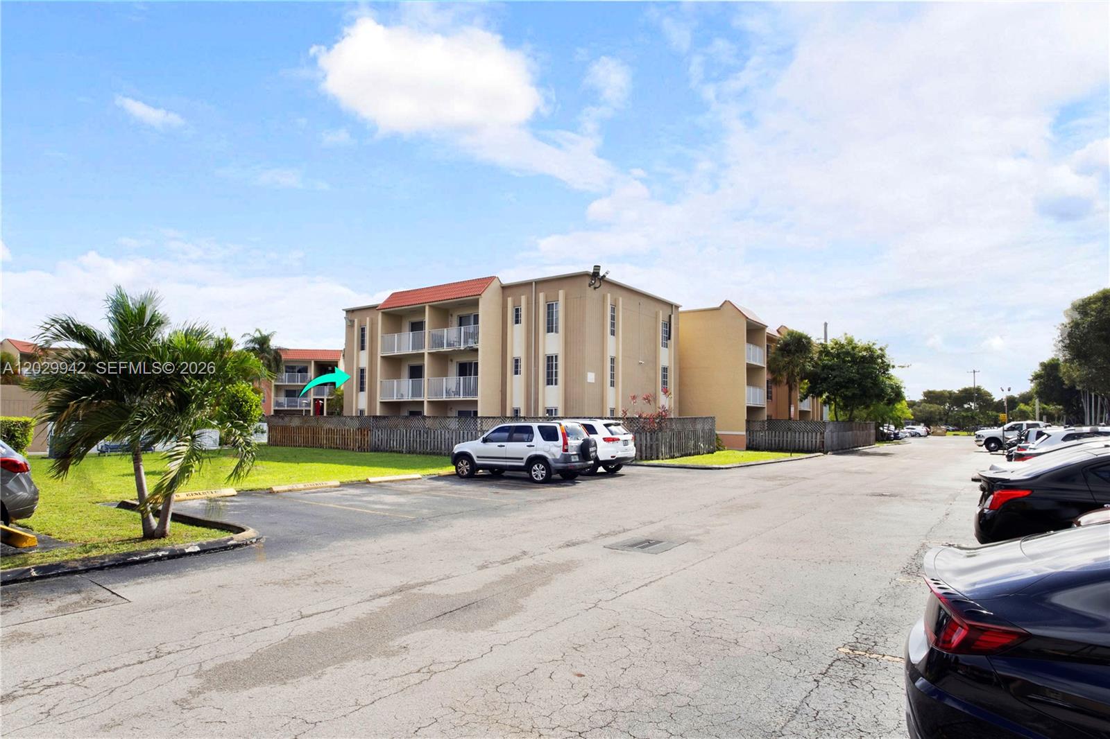 An exterior view shows a multi-story apartment building with balconies and a parking lot — DORAL, FL