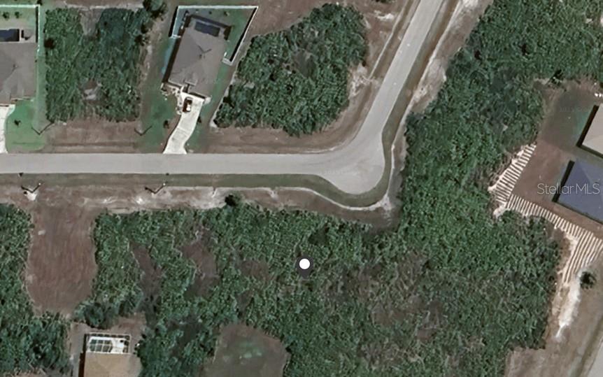 This aerial satellite view shows a vacant residential lot situated along a curved paved road — 112 LIME TREE PARK, ROTONDA WEST, FL