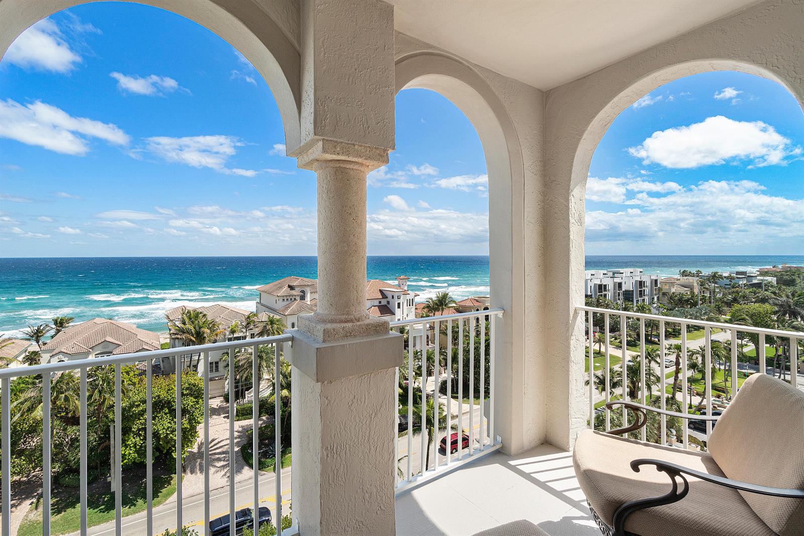 A balcony with arched columns overlooks a coastal neighborhood and the ocean — 3606 S Ocean 1002 Boulevard # 1002, Highland Beach FL 33487, HIGHLAND BEACH, FL