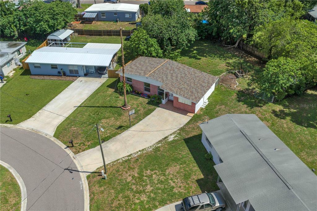 An aerial view shows a single-story house with a brick facade and a concrete driveway — 508 CLEARFIELD ROAD, BRANDON, FL