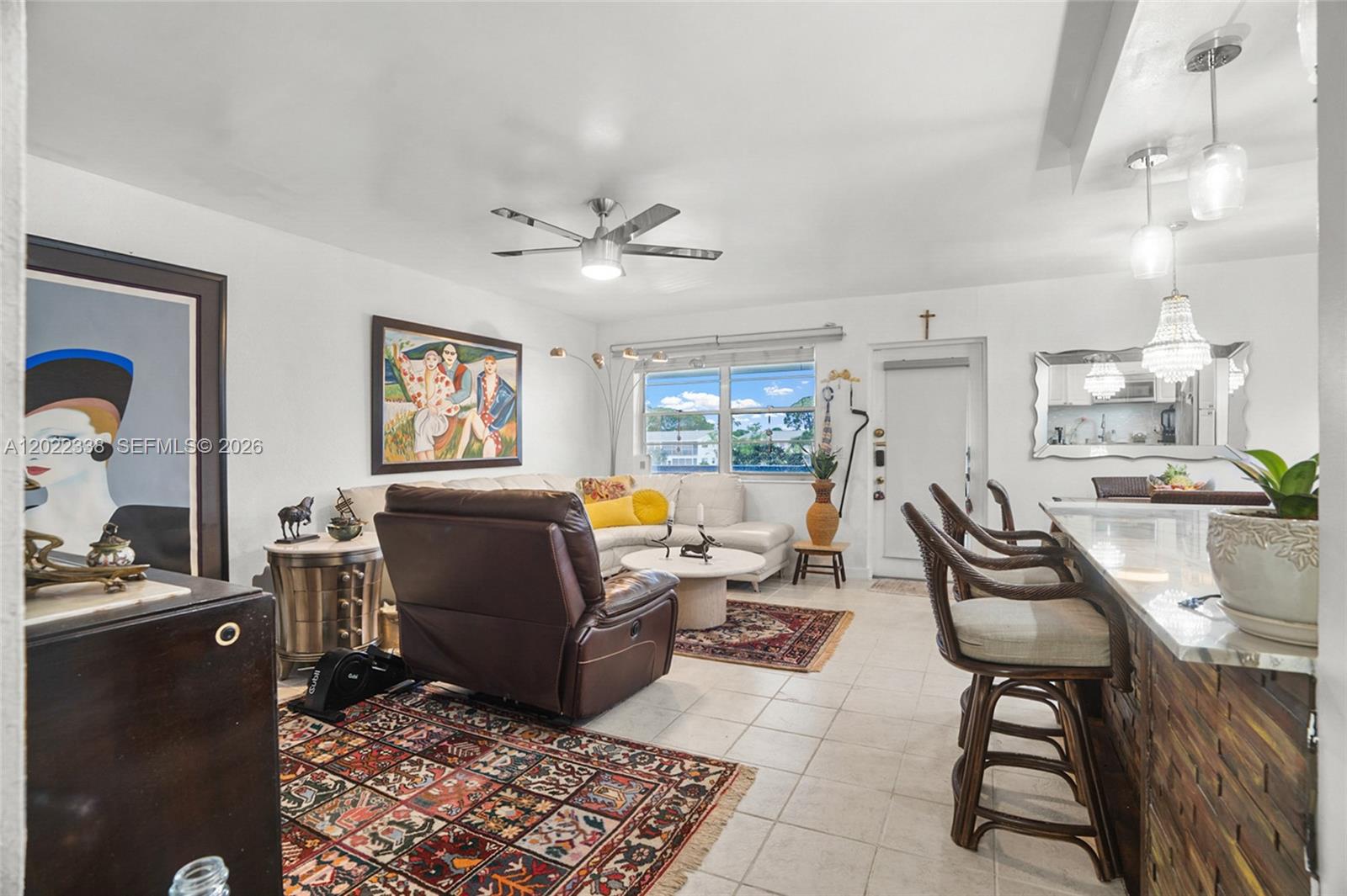 A living room features a brown leather recliner, a sectional sofa, and a breakfast bar — 181 Lyndhurst L # 181, Deerfield Beach FL 33442, DEERFIELD BEACH, FL