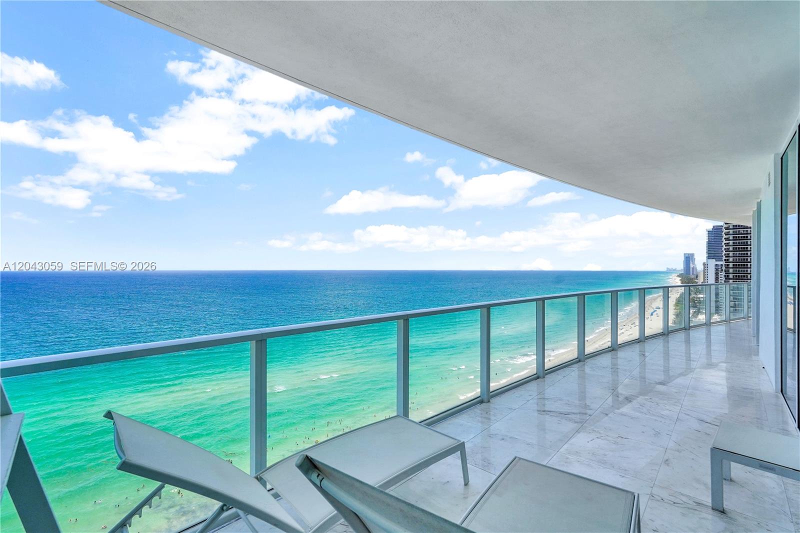 A balcony with marble flooring overlooks the ocean and a sandy beach — 3951 S Ocean Dr # 1901, Hollywood FL 33019, HOLLYWOOD, FL