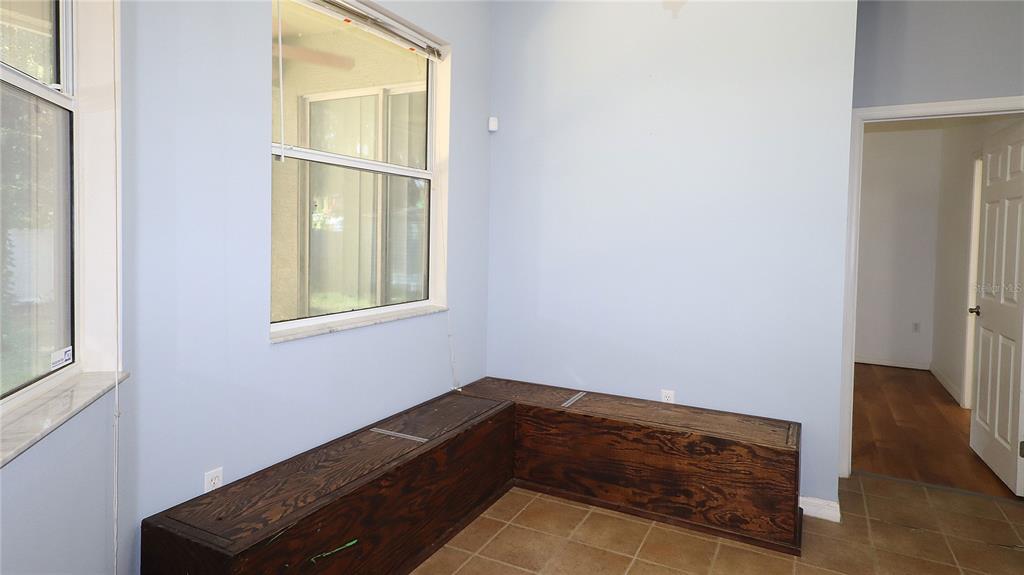 A kitchen with dark wood cabinets, a breakfast bar, and tile flooring — 3114 NE 24TH PLACE, OCALA, FL