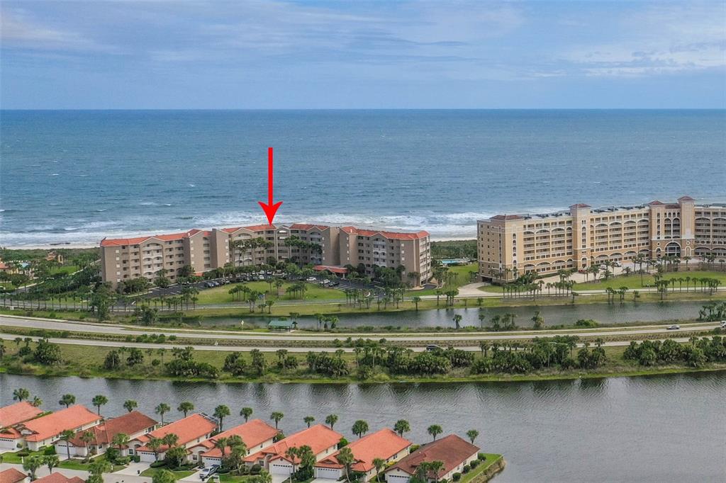 An aerial view of a beachfront resort complex with a red arrow pointing toward it — 104 SURFVIEW DRIVE UNIT 1608, PALM COAST, FL