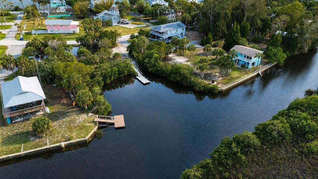 An aerial view shows several houses situated along a narrow canal with private docks — 10166 CABANA STREET, WEEKI WACHEE, FL