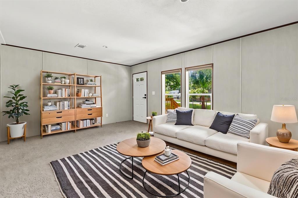 A living room features a white sofa, two round coffee tables, and a wooden bookshelf — 25046 CELESTIAL STREET, CHRISTMAS, FL