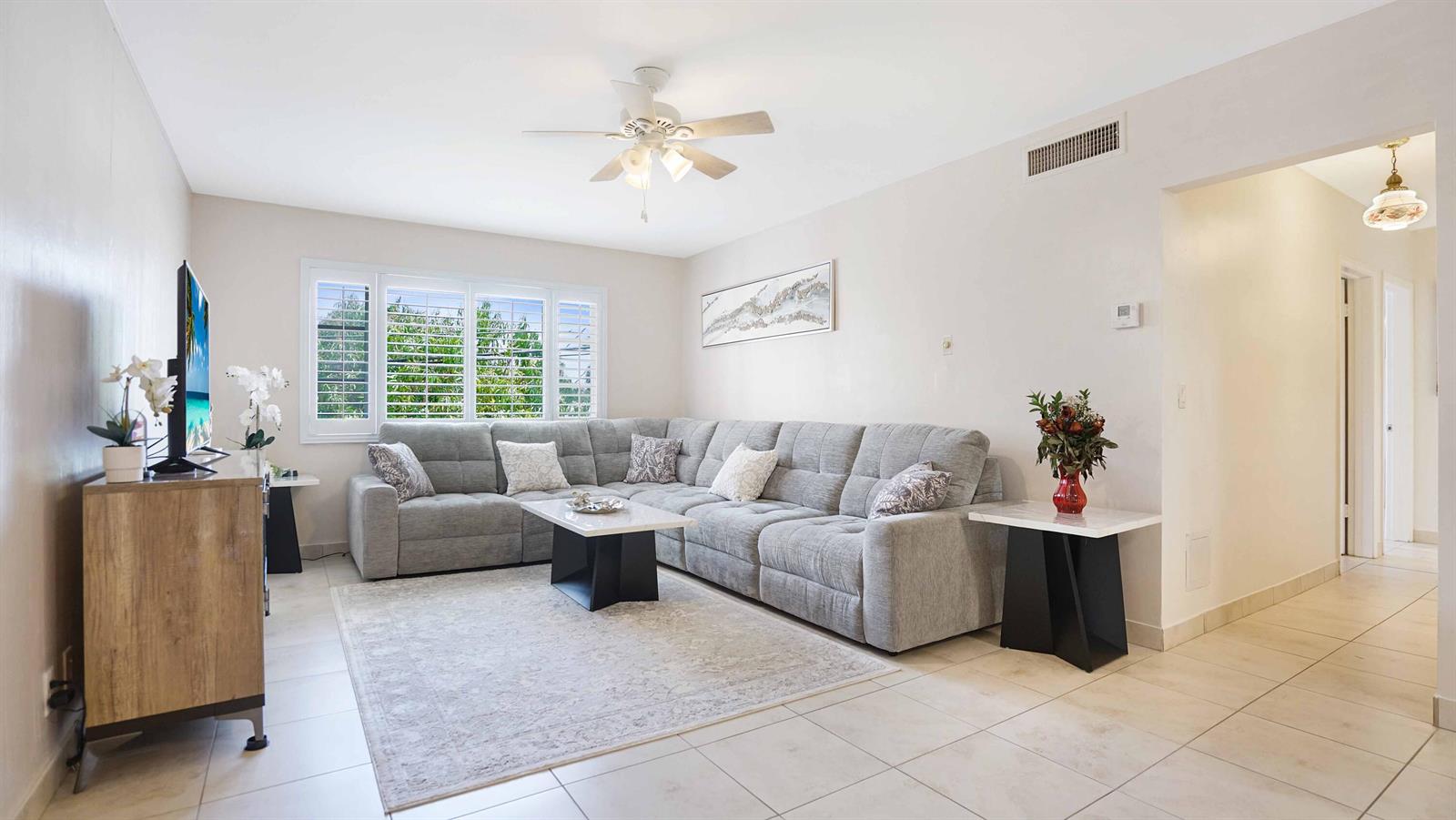 A living room features a gray sectional sofa, a coffee table, and tile flooring — 400 S Cypress Road # 428, Pompano Beach FL 33060, POMPANO BEACH, FL
