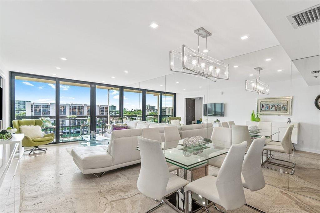 A modern living and dining area with white furniture, tile floors, and floor-to-ceiling windows — 2707 N Ocean Boulevard # D603, Boca Raton FL 33431, BOCA RATON, FL