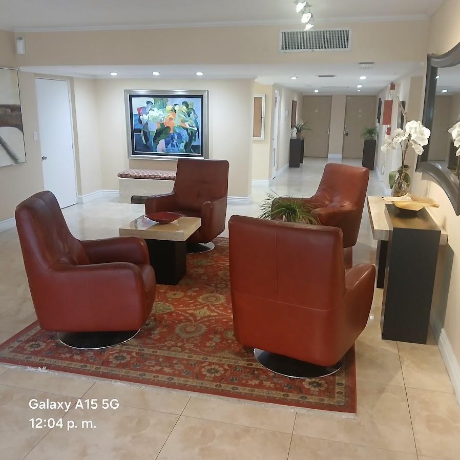 A lobby seating area features four leather armchairs arranged around a rug on tile flooring — 800 Cypress Grove Drive Unit 312, Pompano Beach FL 33069, POMPANO BEACH, FL