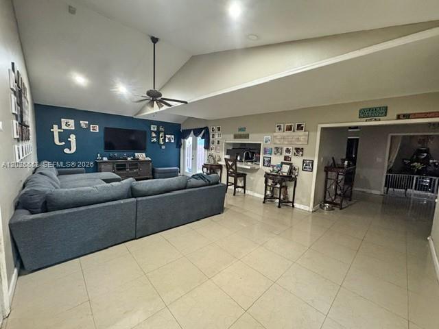 A spacious living room features a large blue sectional sofa, vaulted ceilings, and tile flooring — 21705 SW 99th Ave, Cutler Bay FL 33190, CUTLER BAY, FL