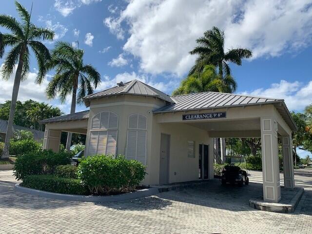 A gated community entrance with a metal roof, beige walls, and a clearance sign — 26 Royal Palm Way # 302, Boca Raton FL 33432, BOCA RATON, FL