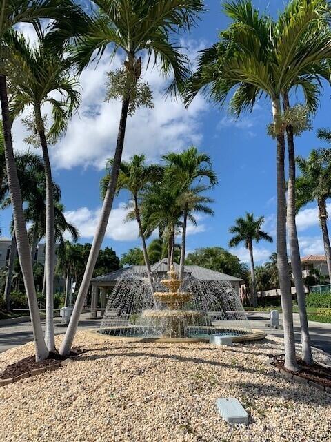 A tiered fountain sits in a gravel landscape surrounded by several tall palm trees — 26 Royal Palm Way # 302, Boca Raton FL 33432, BOCA RATON, FL