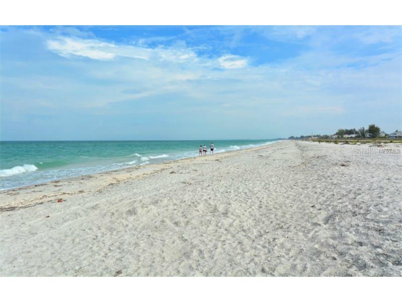 A wide, sandy beach stretches along the ocean under a blue, cloudy sky — 12319 BONITA PLACE, PLACIDA, FL
