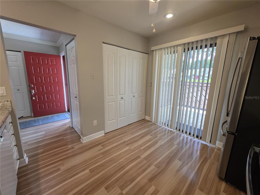 A dining area features wood-look flooring, a white closet, and sliding glass doors with blinds — 4045 BLUFF OAK COURT, PALM HARBOR, FL