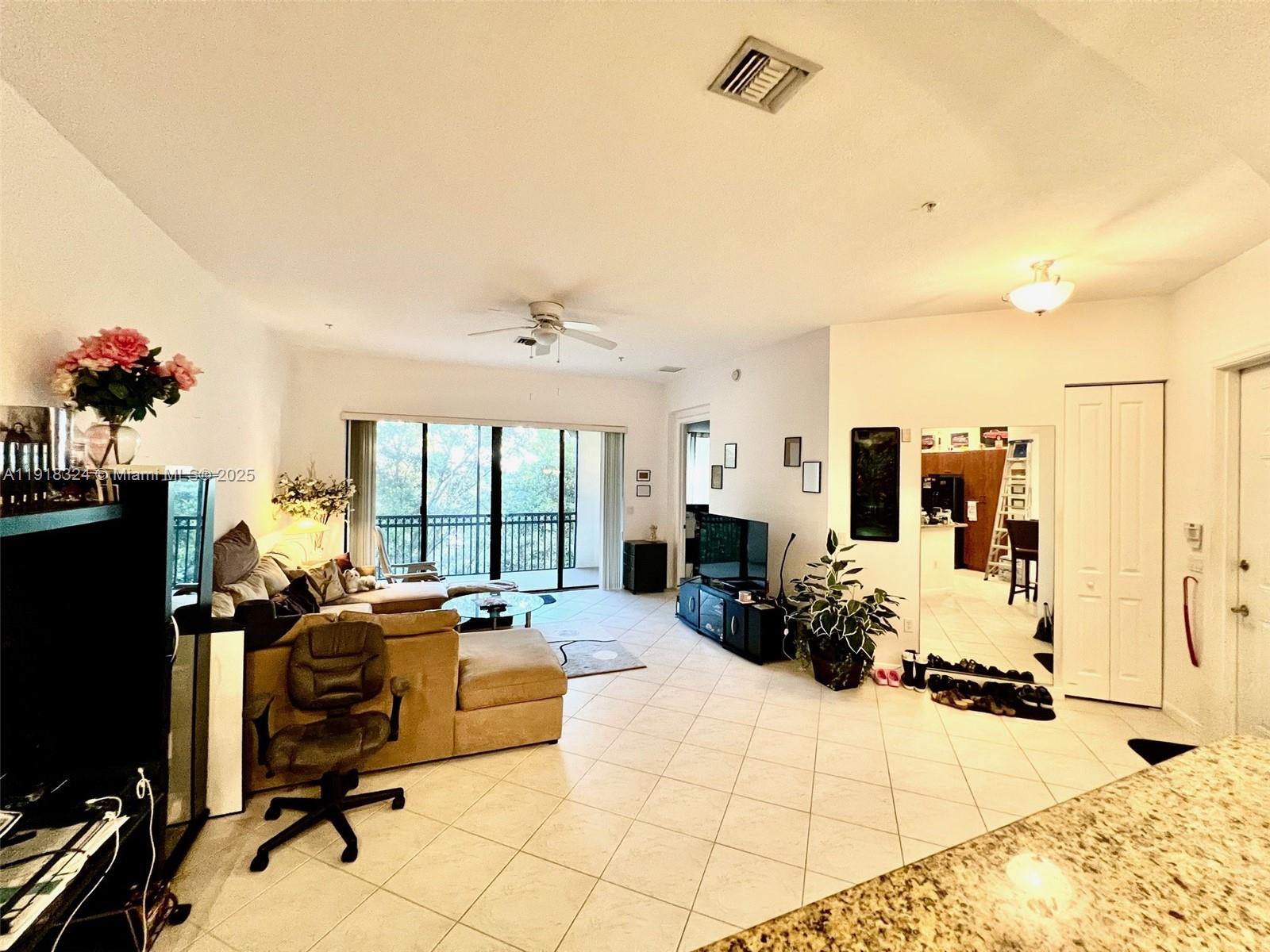 A living room features tile flooring, a sectional sofa, a ceiling fan, and a balcony — 2901 NW 126th Ave # 415, Sunrise FL 33323, SUNRISE, FL