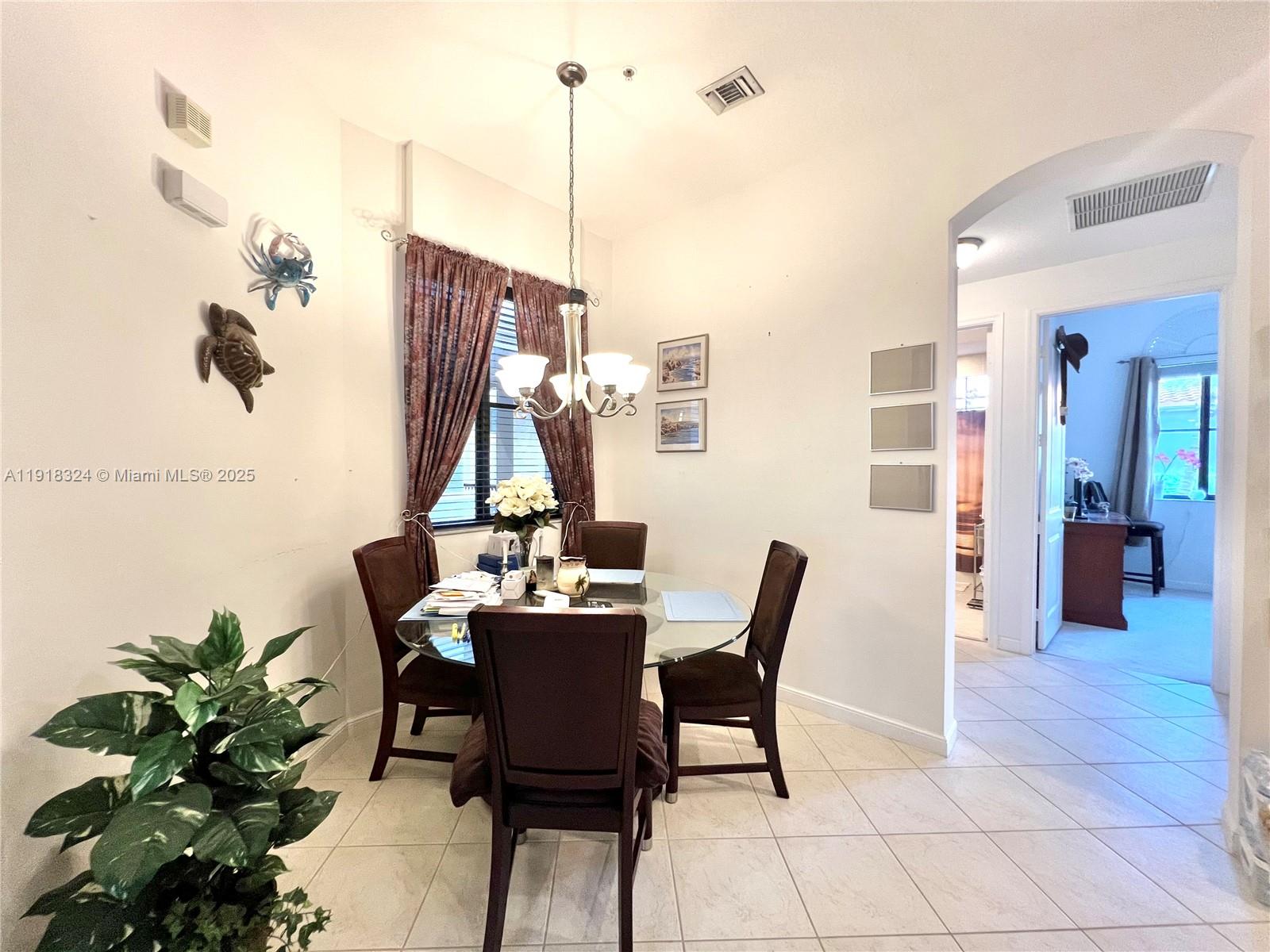 A dining area features a glass table, four chairs, a chandelier, and tile flooring — 2901 NW 126th Ave # 415, Sunrise FL 33323, SUNRISE, FL
