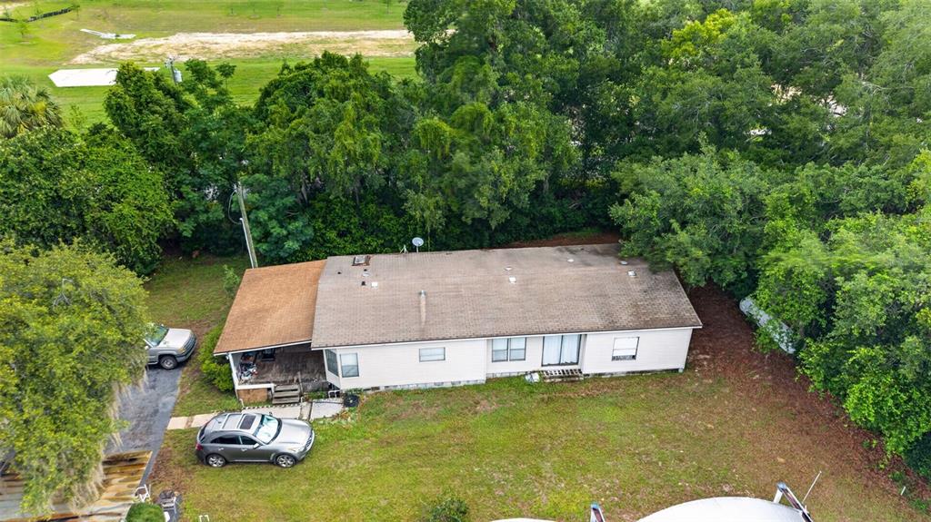 An aerial view shows a single-story house with a brown roof surrounded by dense trees — 2866 LENT ROAD, APOPKA, FL