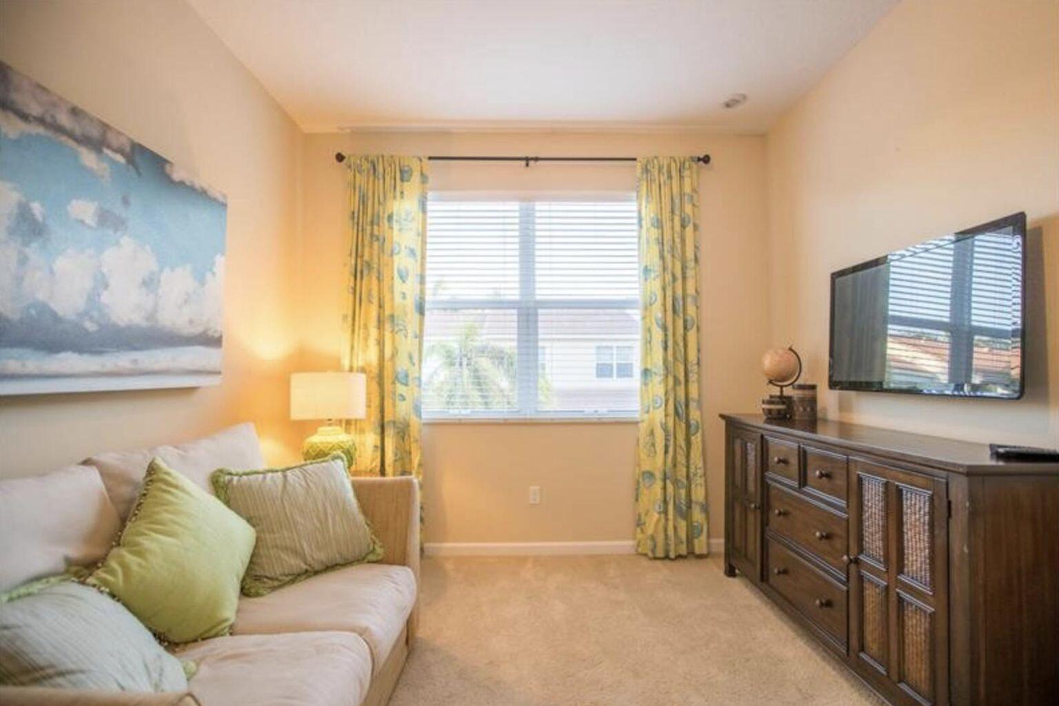 A small living room features a beige sofa, a wooden media console, and yellow curtains — 1485 NW 48th Drive, Boca Raton FL 33431, BOCA RATON, FL