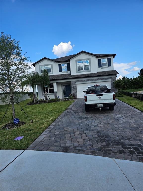 A two-story house with a white truck parked on a paved driveway — 38049 COPPER PENNY COURT, ZEPHYRHILLS, FL
